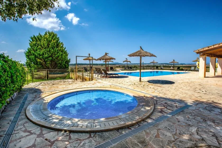 An outdoor pool area with a small circular pool in the foreground.