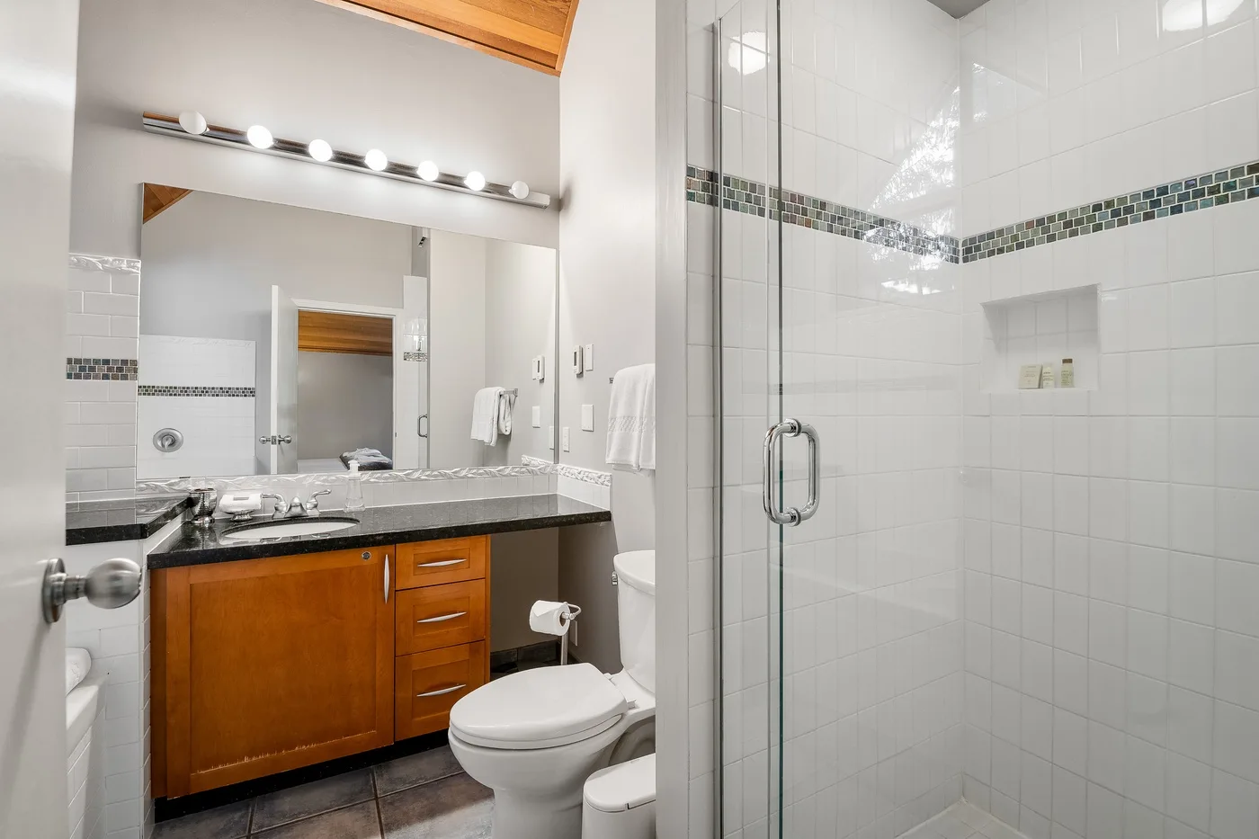 Un baño con lavabo, espejo y ducha de vidrio.