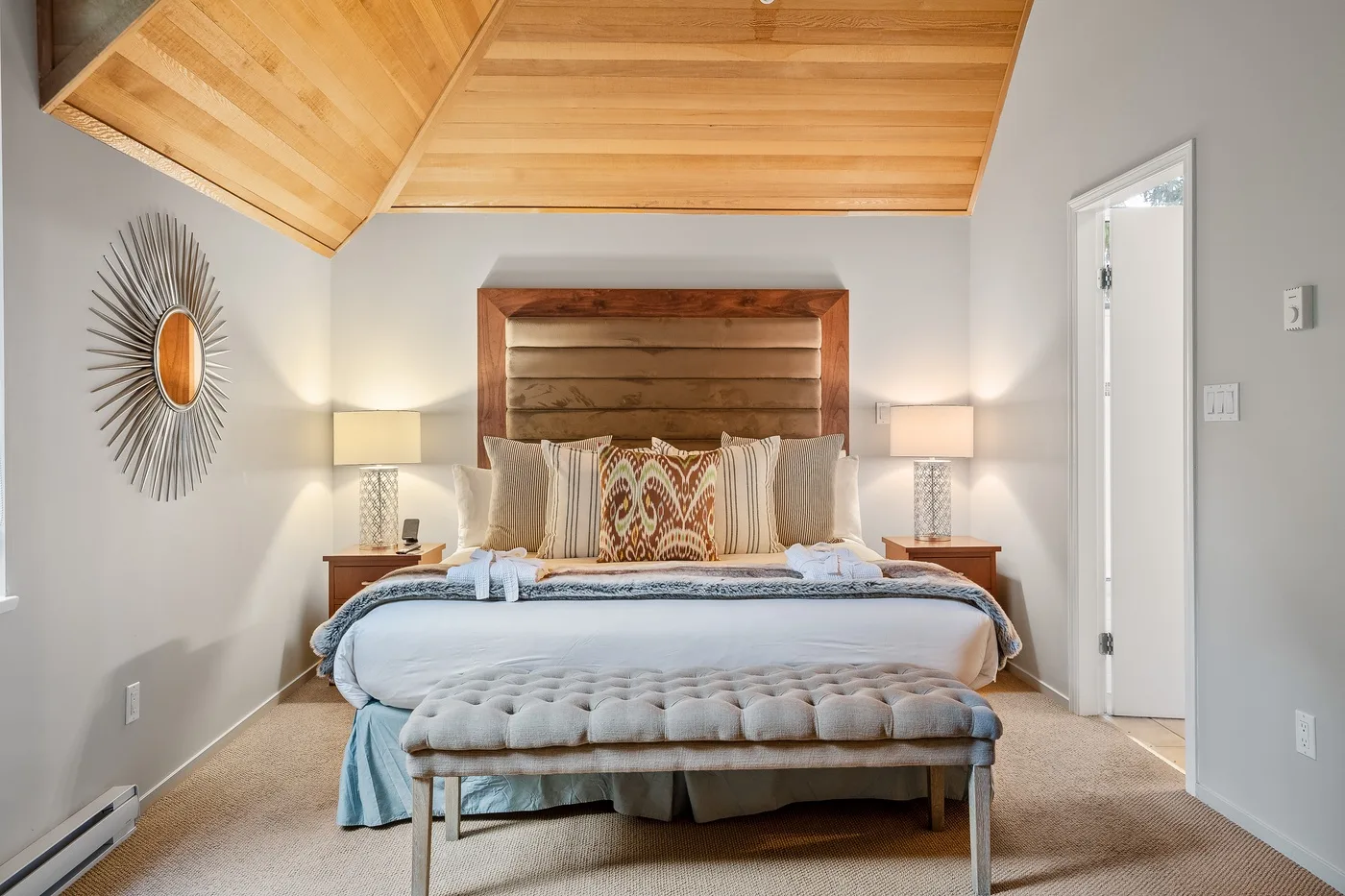 Un dormitorio con una cama bajo un techo inclinado de madera.