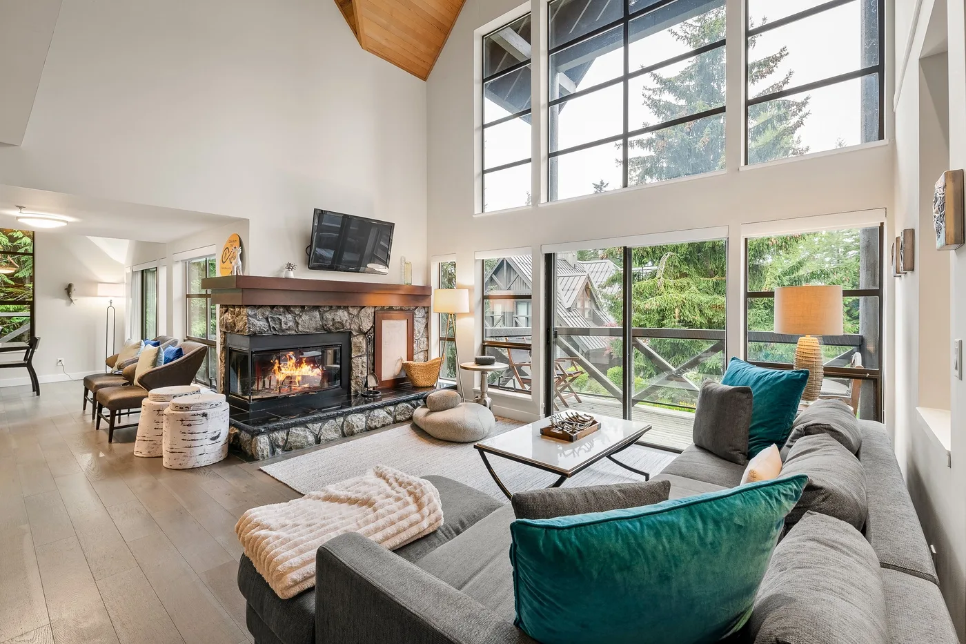 Una sala luminosa con grandes ventanas, una chimenea y asientos.