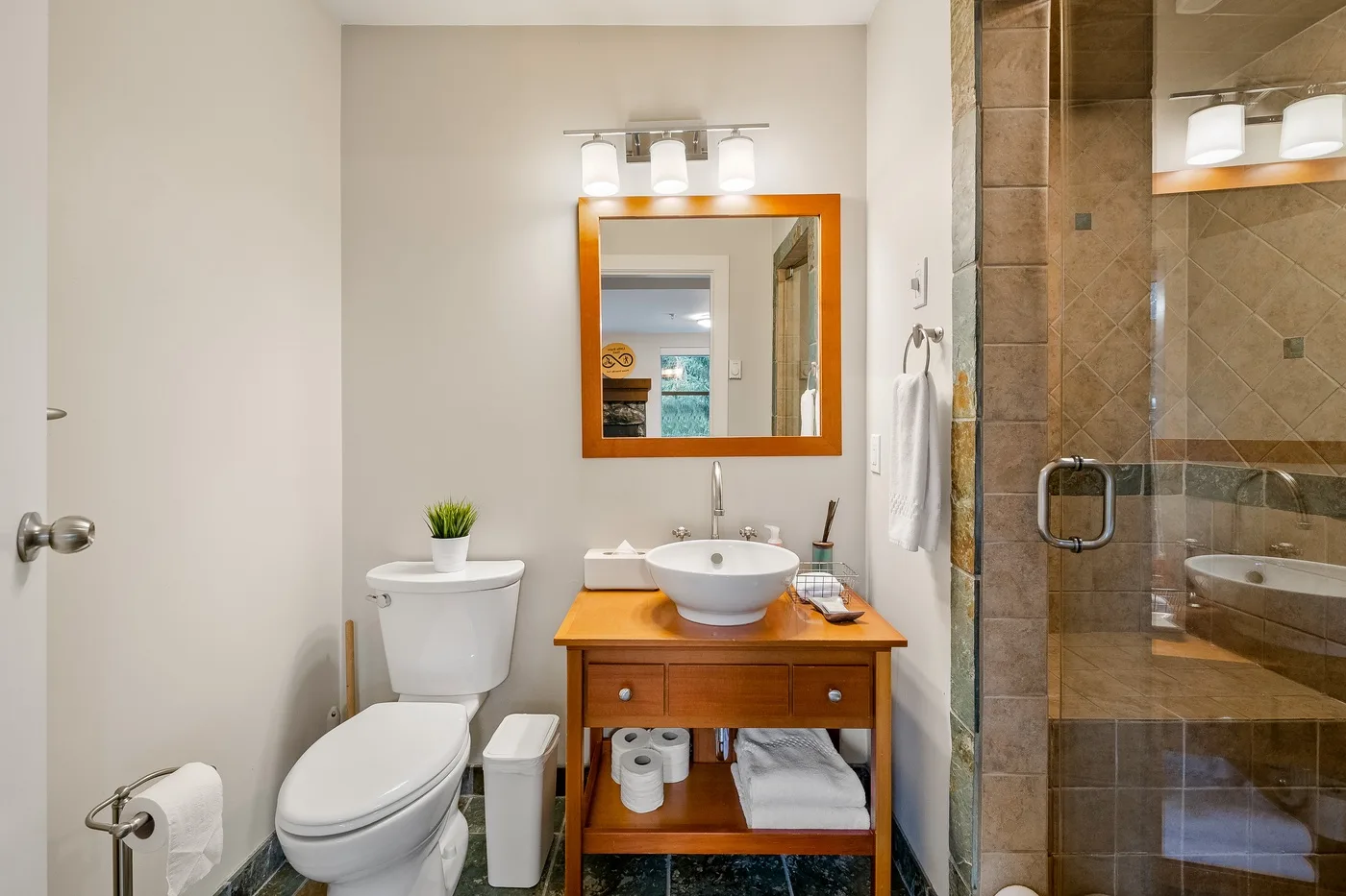 Un baño con lavabo, inodoro y ducha con mampara de vidrio.