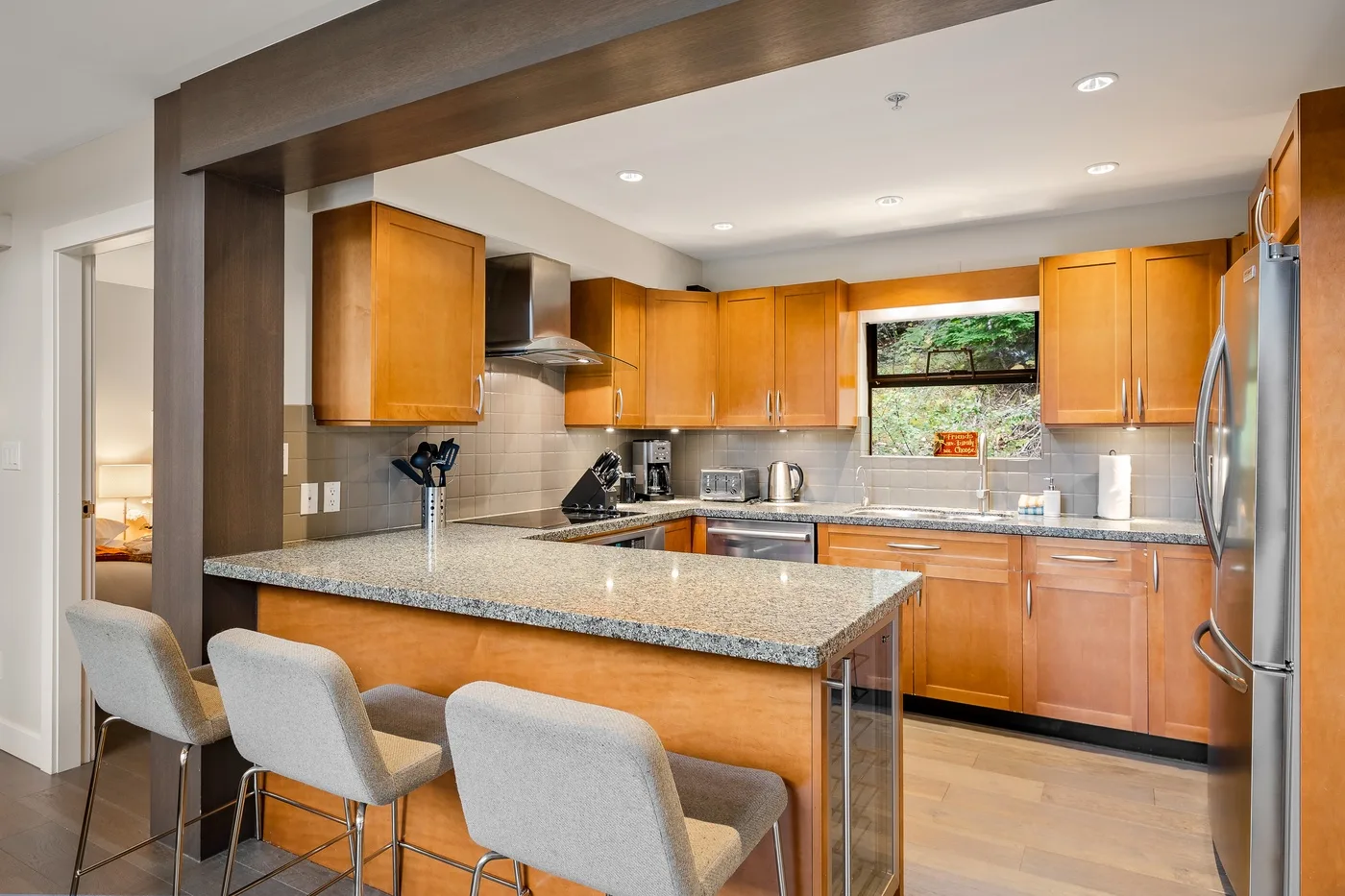 Una cocina luminosa con gabinetes de madera y una amplia isla con asientos.