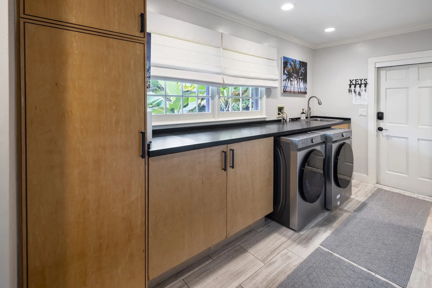 A laundry room with front-loading machines beneath a long countertop.