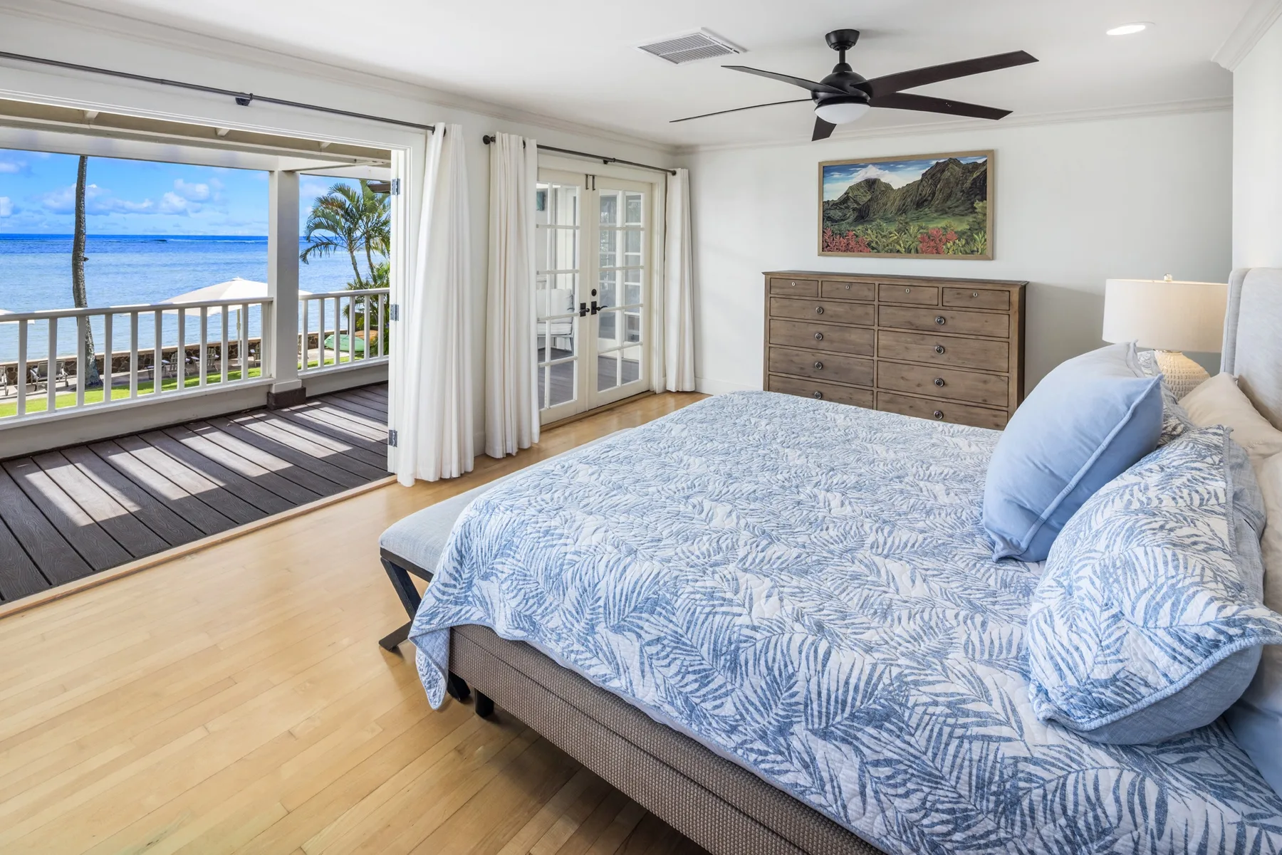 A bedroom with a bed beside a sliding glass door opening onto a balcony.