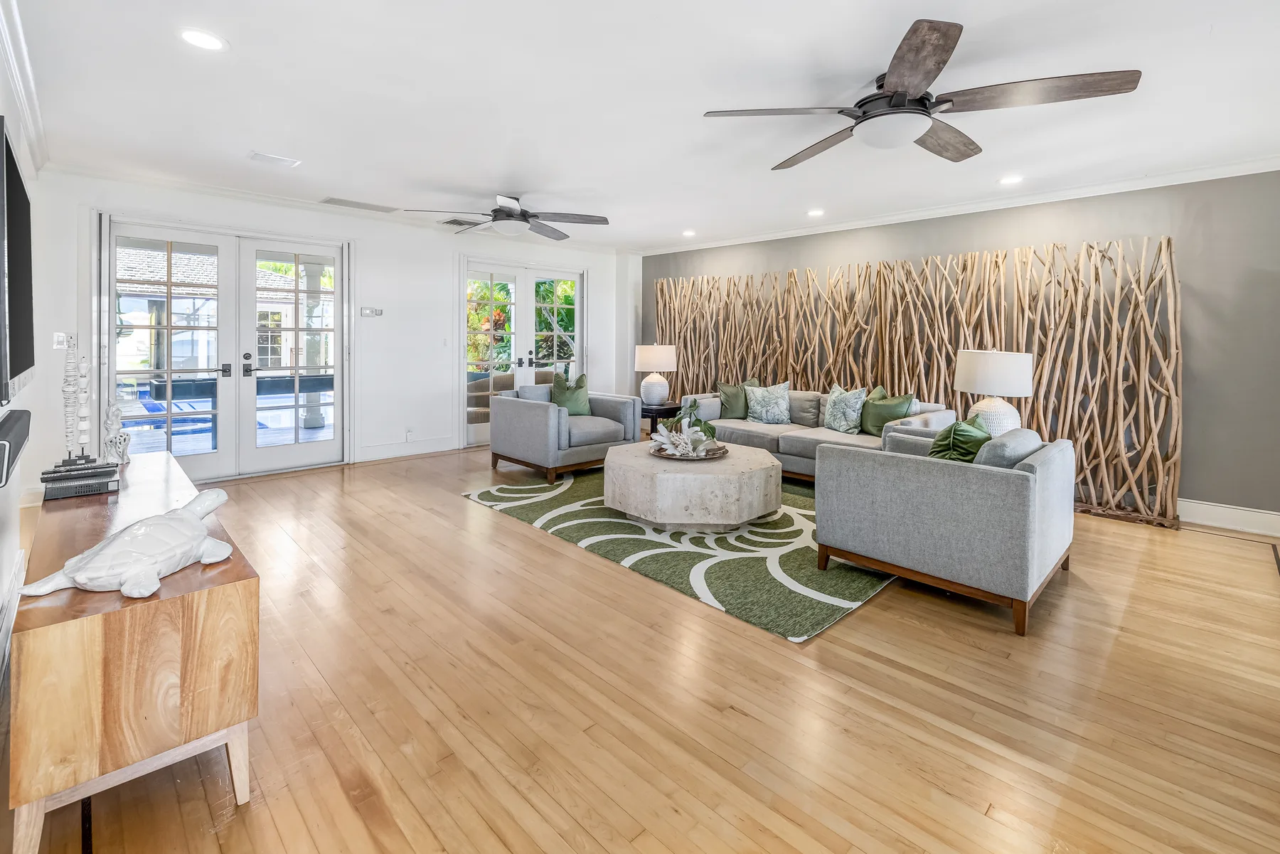 A bright living room with seating around a low table on a patterned rug.