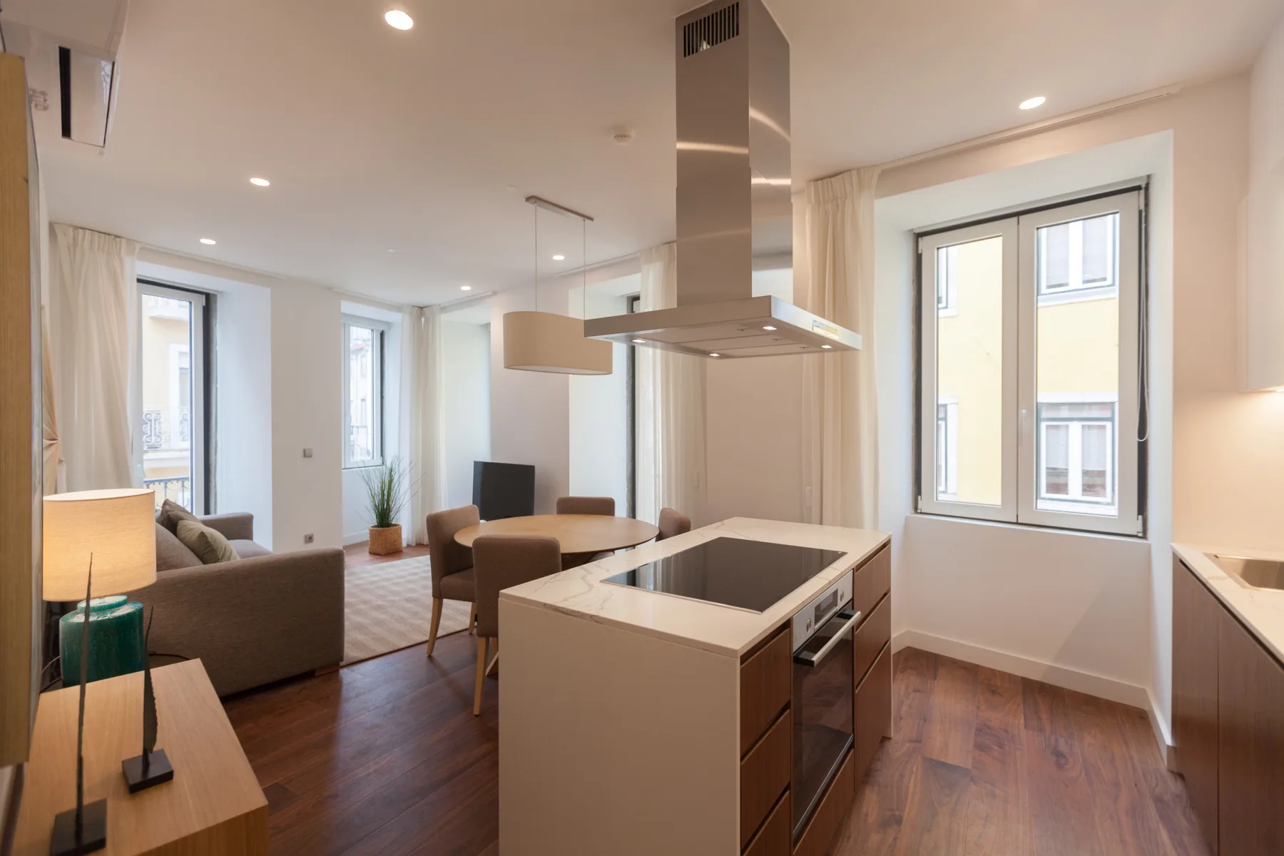 Cocina y sala de estar diáfanas con una isla central y asientos.