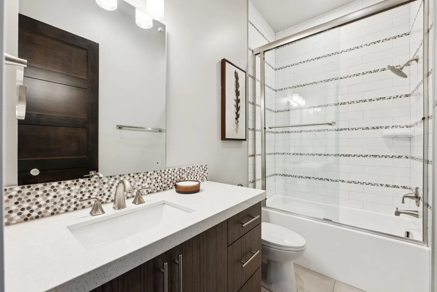 A bright bathroom with a wide vanity beside a glass shower.