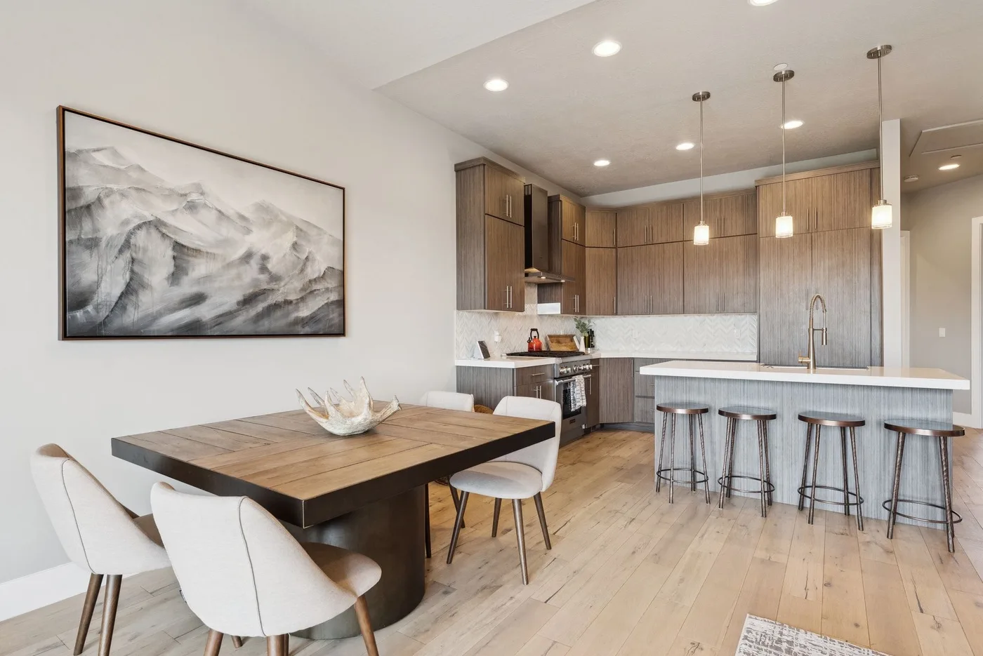 An open-plan kitchen and dining area with a wooden table and island seating.