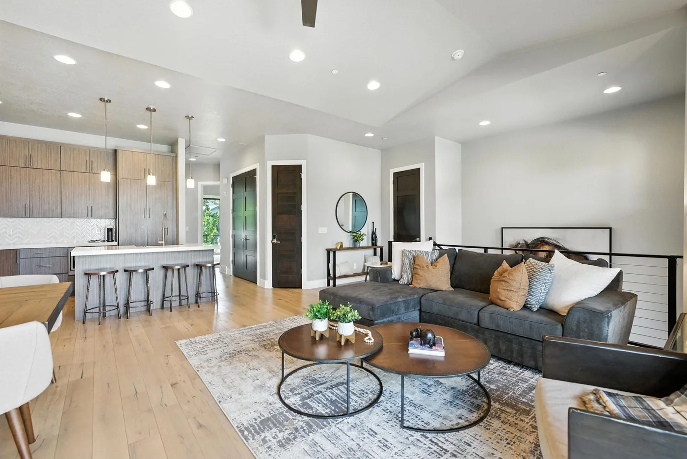 Open-plan living room and kitchen with a sectional sofa and island seating.