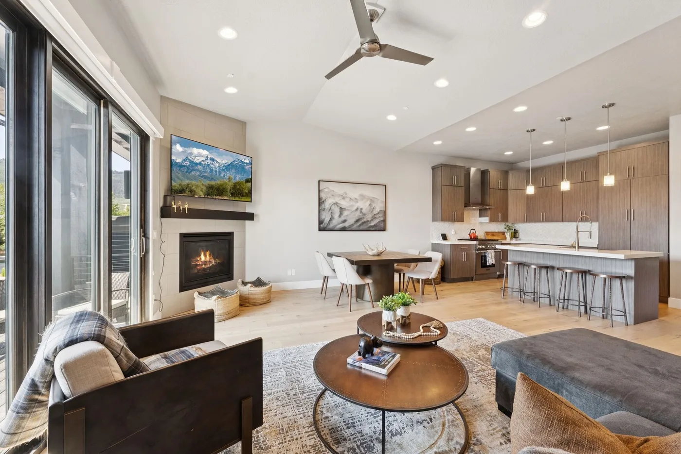 An open-plan living room and kitchen with a fireplace and island seating.