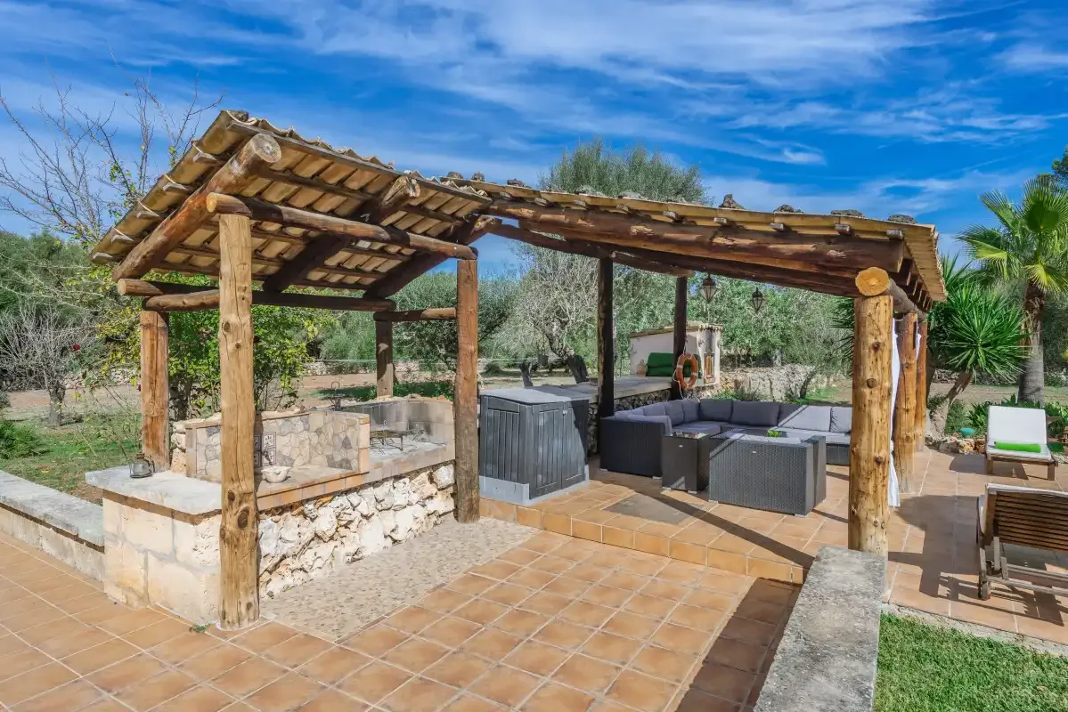Un patio exterior cubierto con asientos y una barra de piedra.
