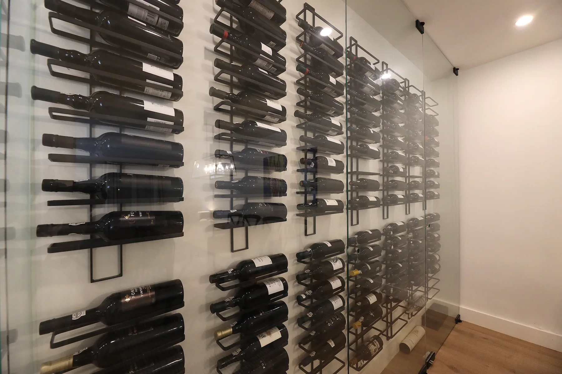 A wine storage room with bottles arranged on wall-mounted racks.