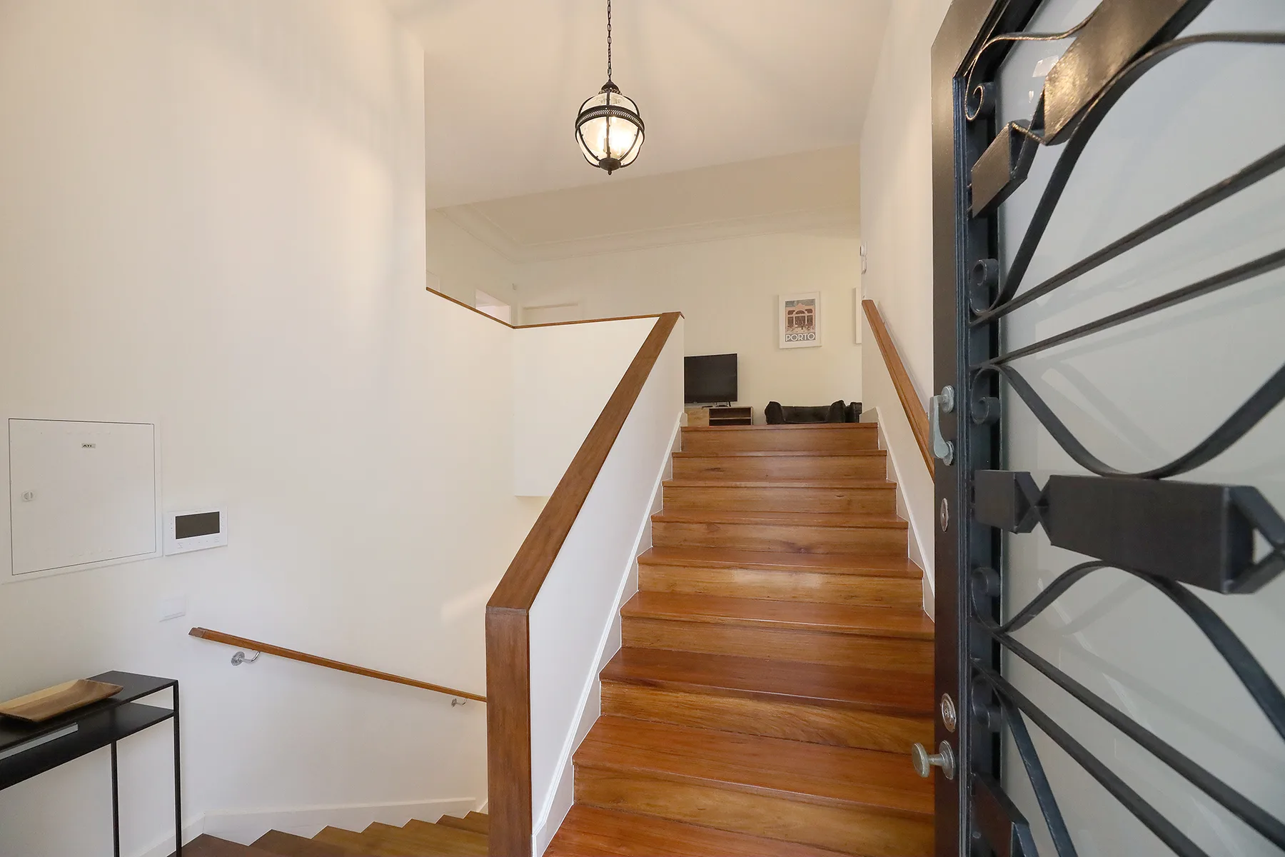 An interior stairway with wooden steps, a handrail, and an open entry door.