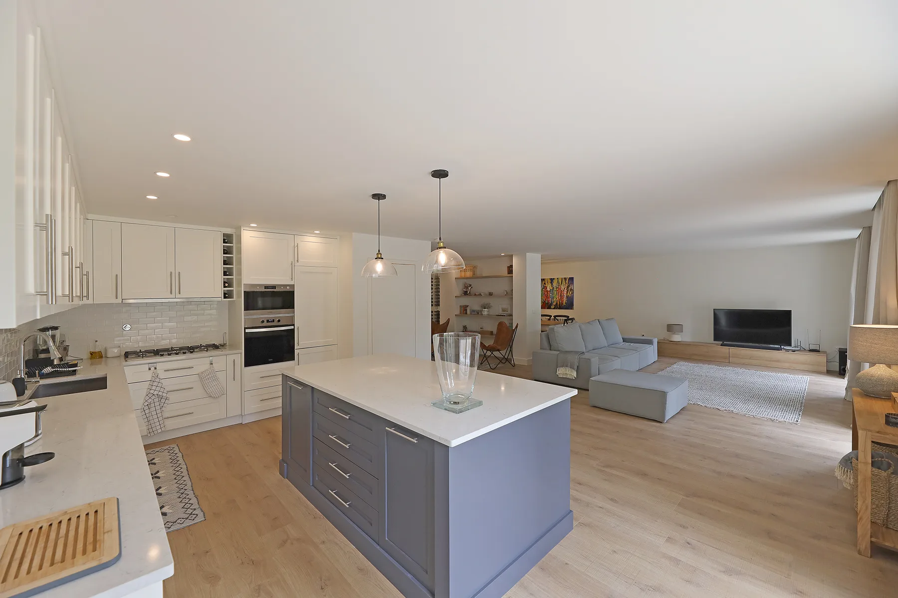 An open-plan kitchen and living area with a central island and seating.