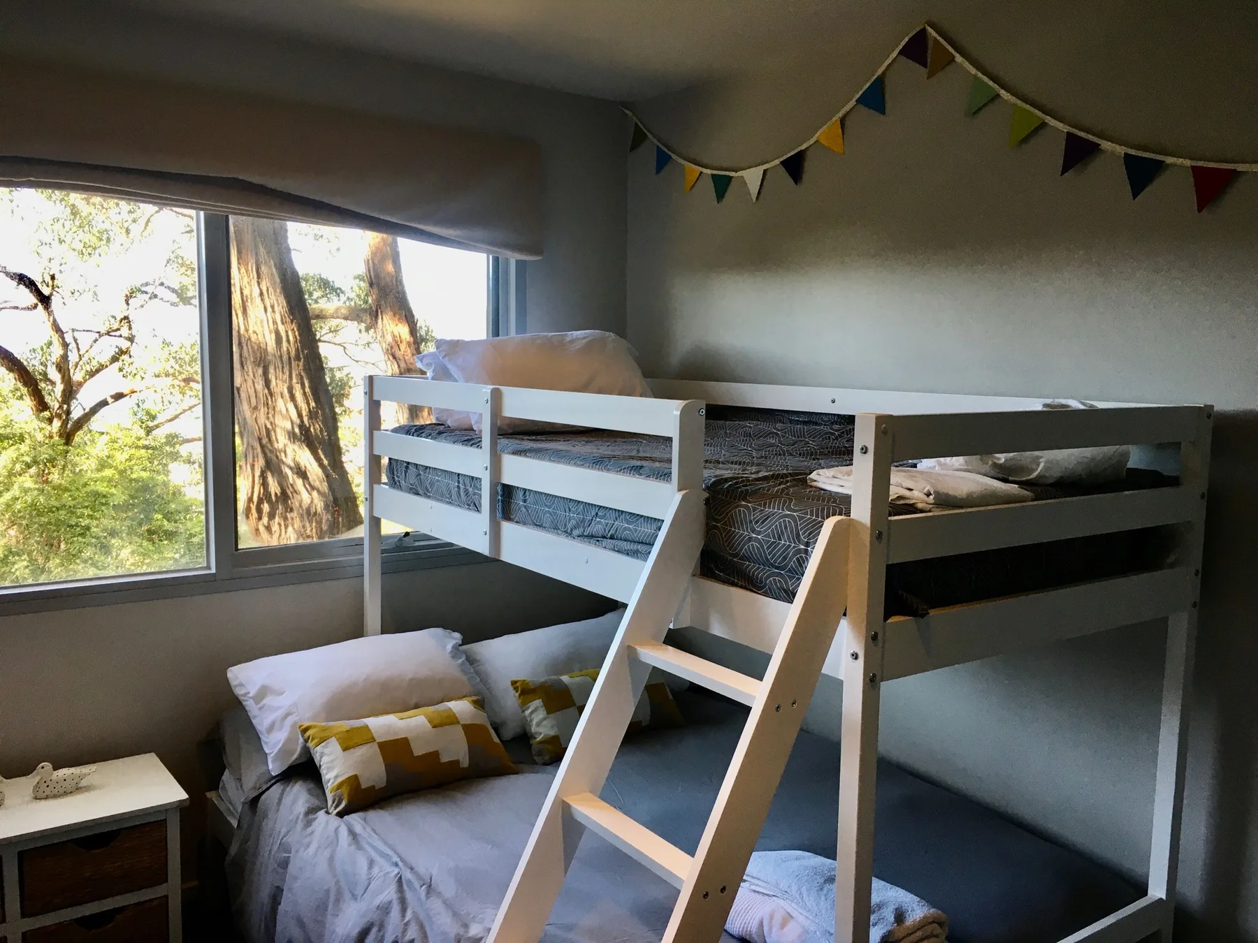 A bunk bed fills a bedroom, with pillows beneath the raised sleeping area.