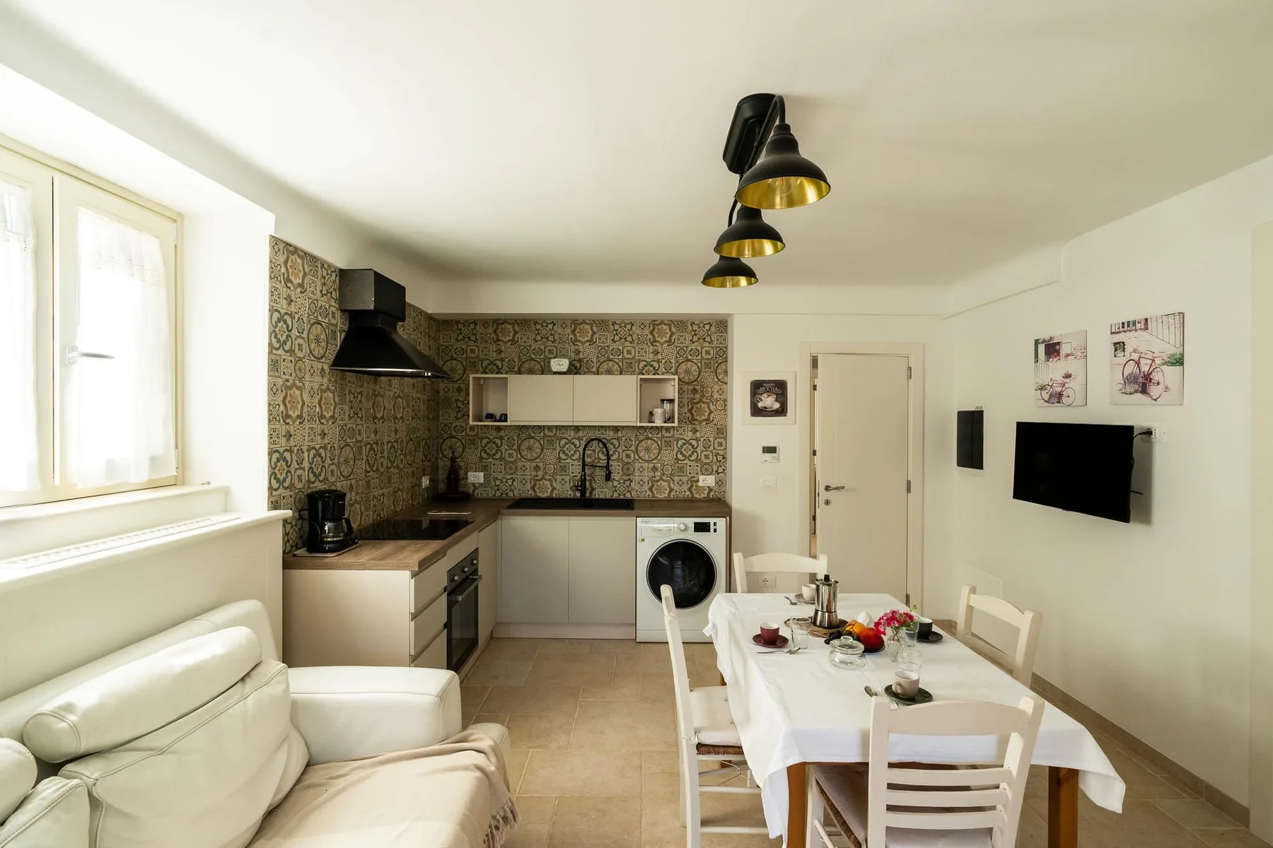 A bright kitchen and dining area with a table set beside the cabinets.