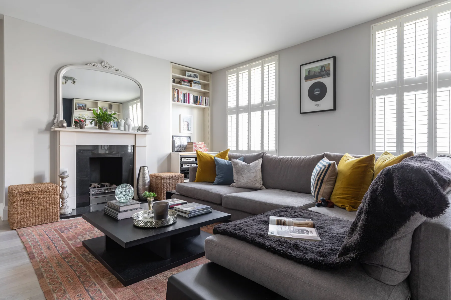 A bright living room with a fireplace, large windows, and seating.