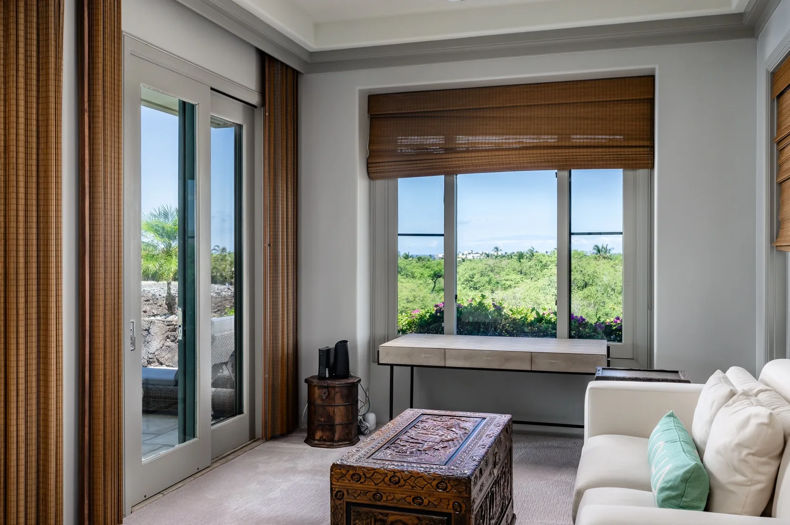Una sala luminosa con grandes ventanas que dan a un paisaje verde.