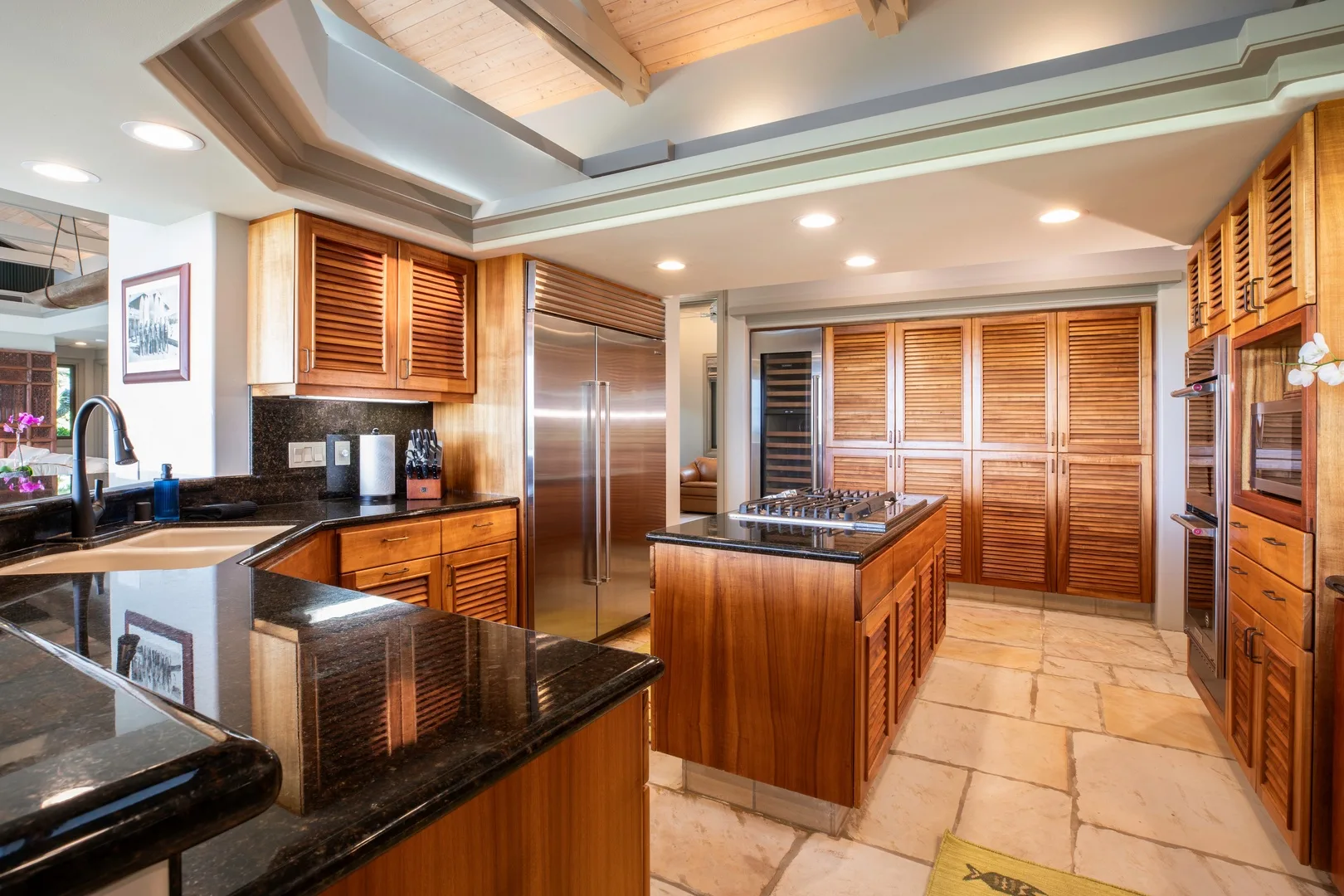 Una cocina amplia con gabinetes de madera, encimeras oscuras y una isla central.
