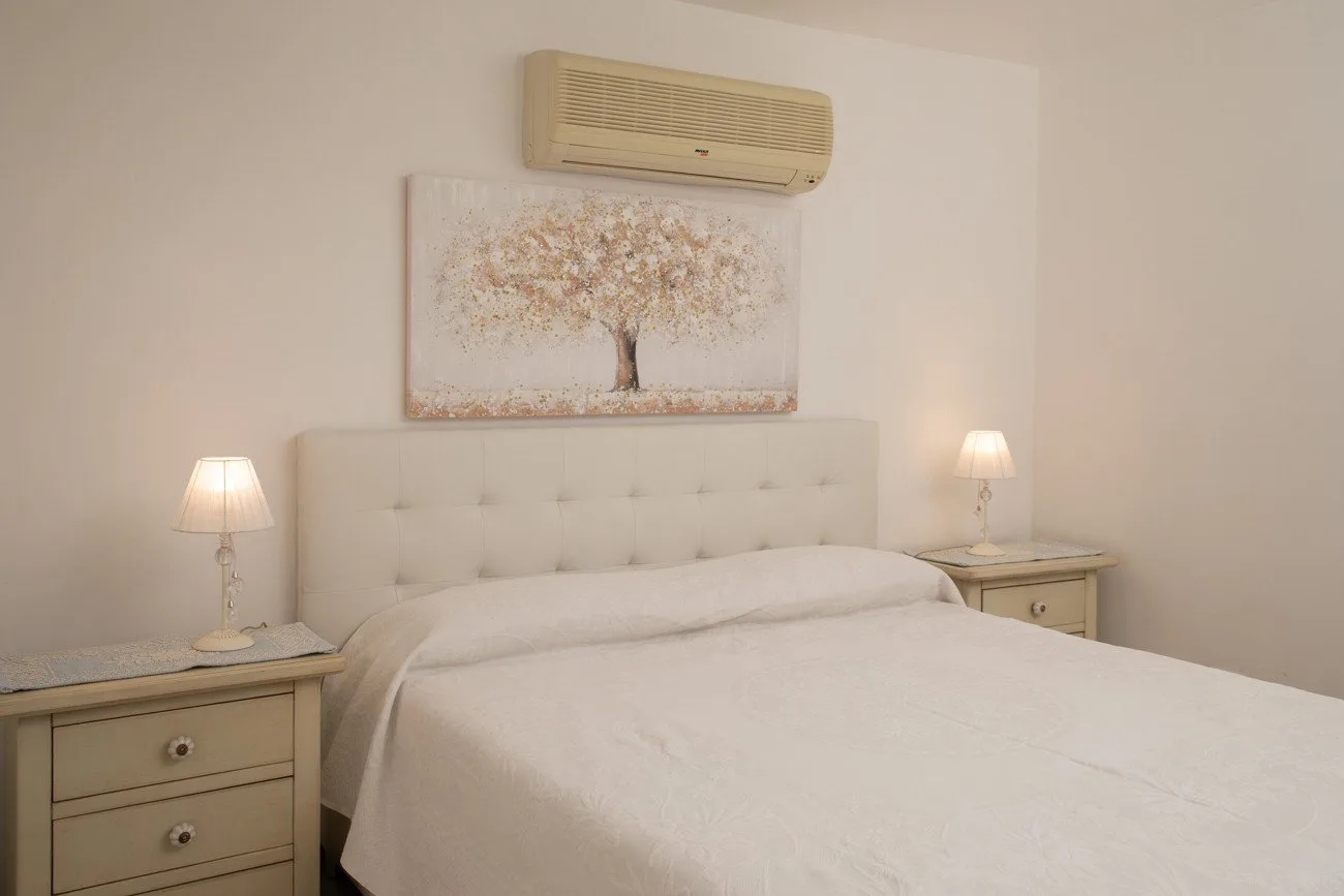 A bedroom with a neatly made bed and matching bedside tables.