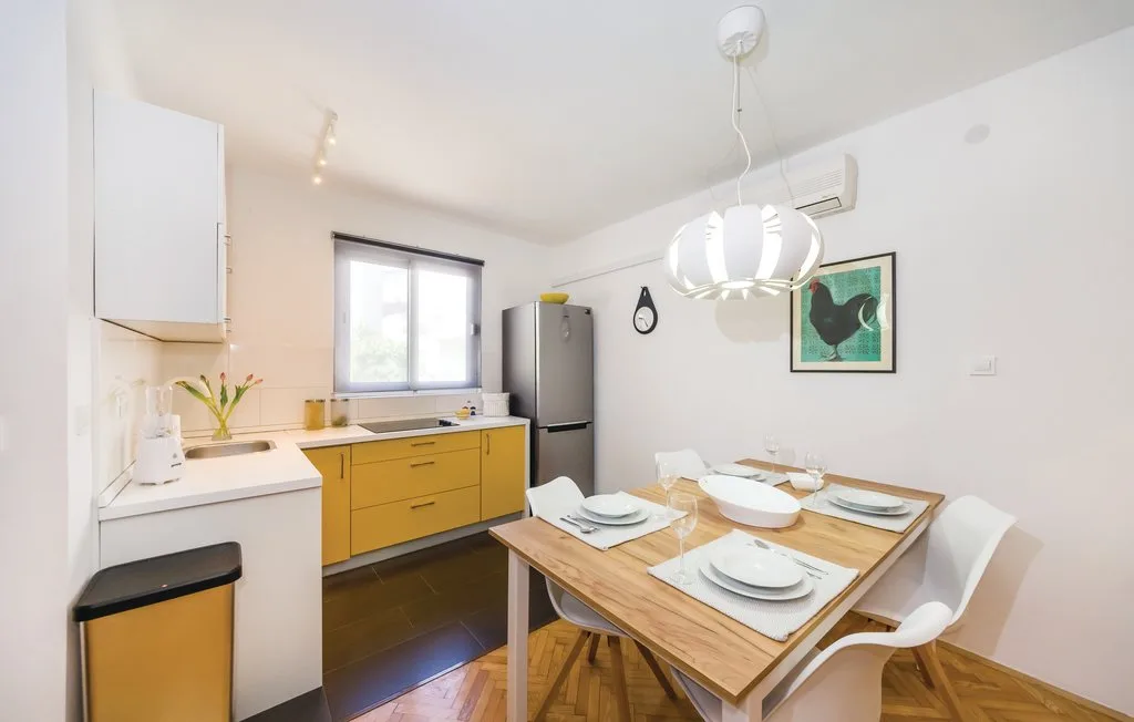 A bright kitchen and dining area with a wooden table set for a meal.