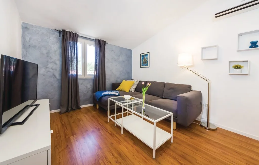 Living room with a sectional seating area, coffee tables, and a window.