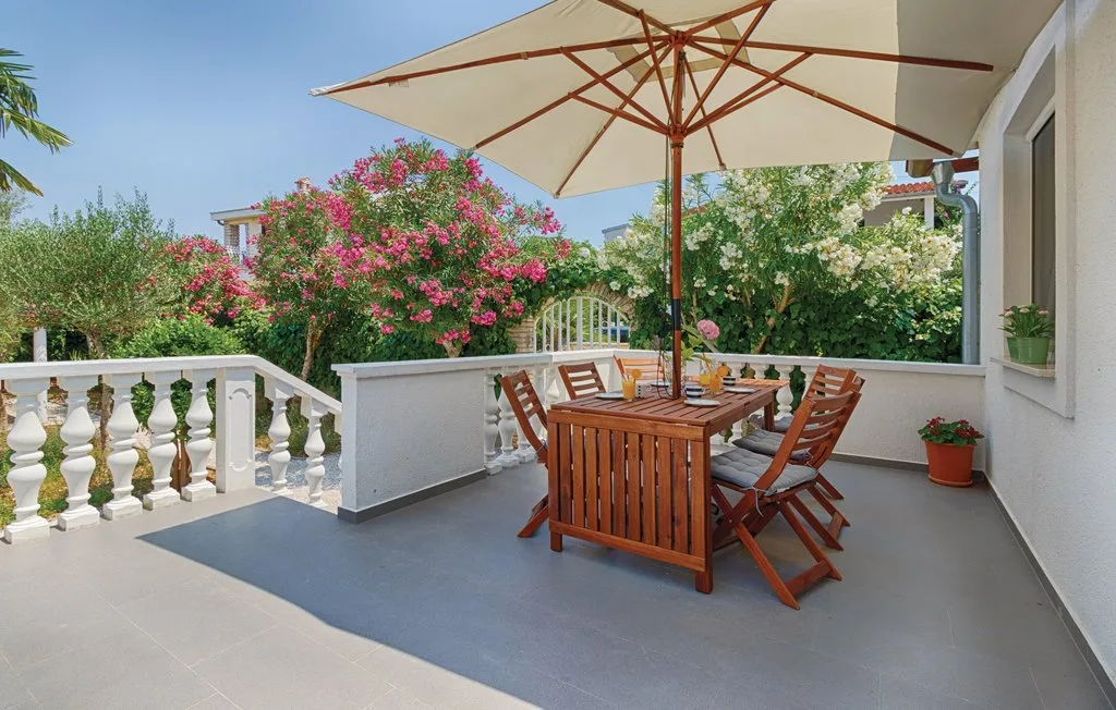 An outdoor dining area with wooden seating and a large patio umbrella.