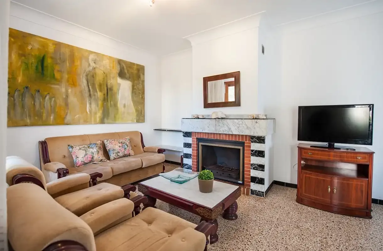 Una sala de estar con asientos alrededor de una chimenea y un televisor.