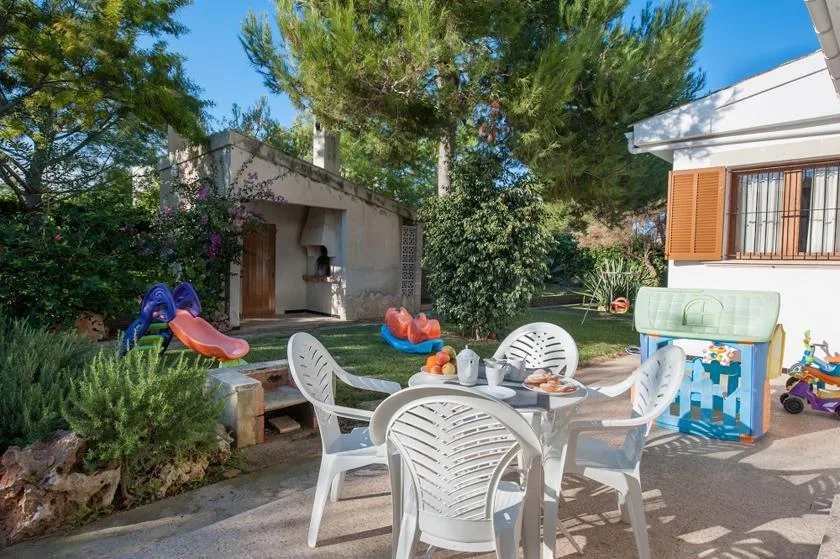 A garden patio has outdoor seating and a small children's play area.