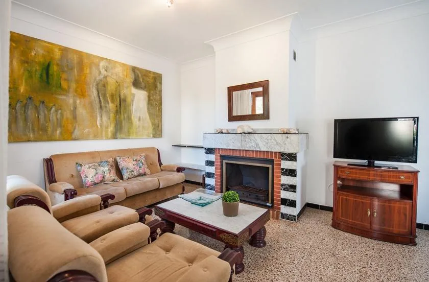 Una sala de estar con asientos junto a una chimenea y un televisor.