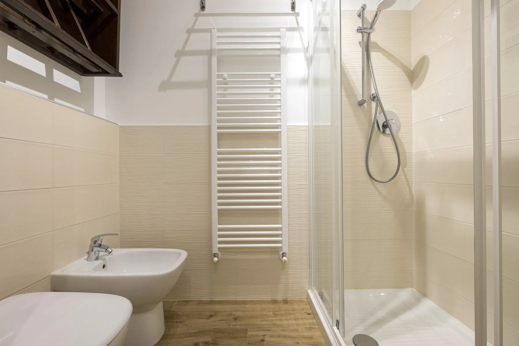 Un baño alicatado con lavabo, inodoro y ducha de cristal.