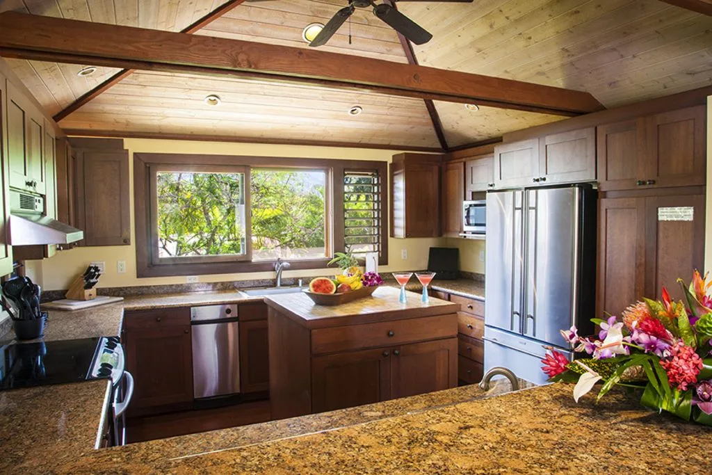 A wood-paneled kitchen with a central island and large windows.