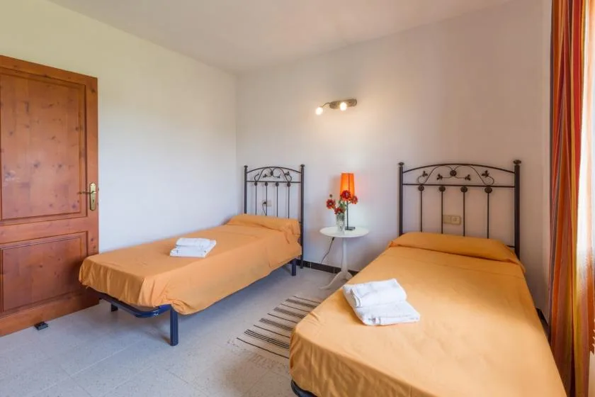 A bedroom with two single beds and a small table between them.