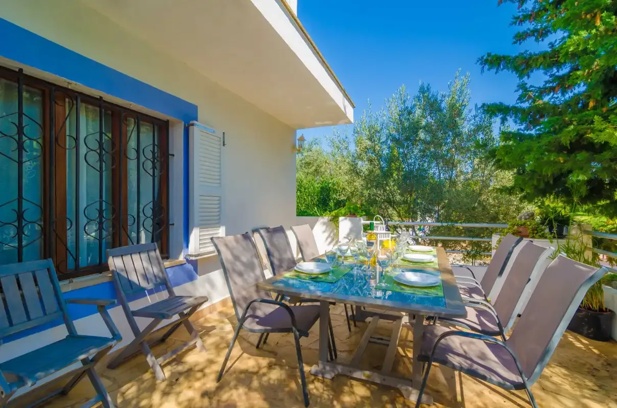 A patio dining area with a glass table and outdoor seating.