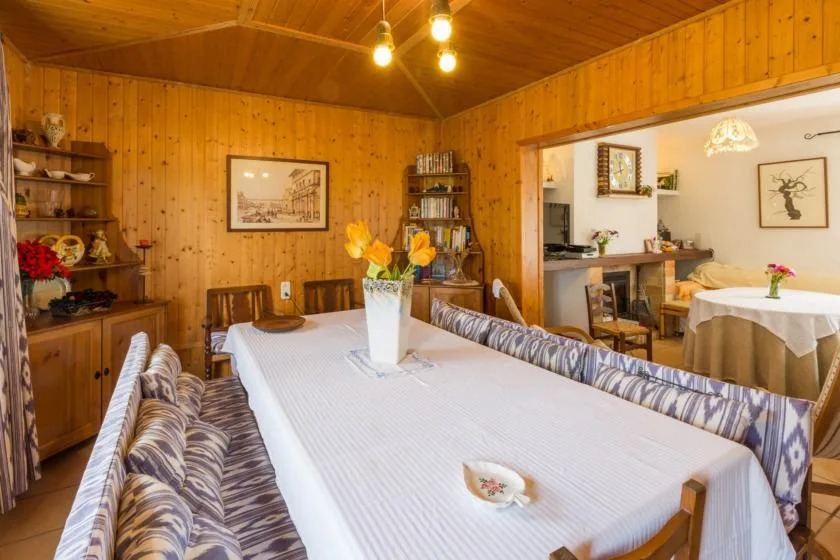 A wood-paneled dining room with a long table and cushioned seating.