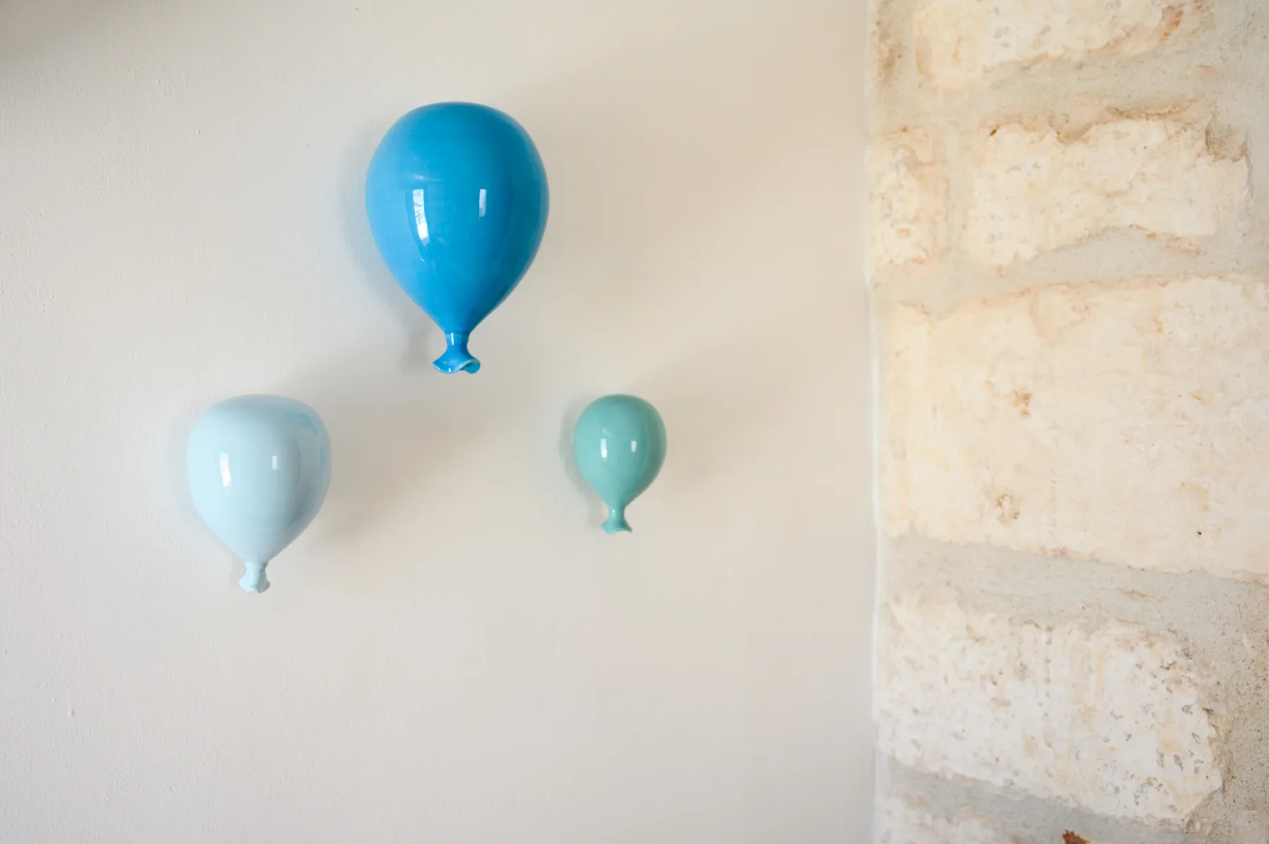 Un globo azul brillante adorna una pared clara junto a una superficie de piedra.