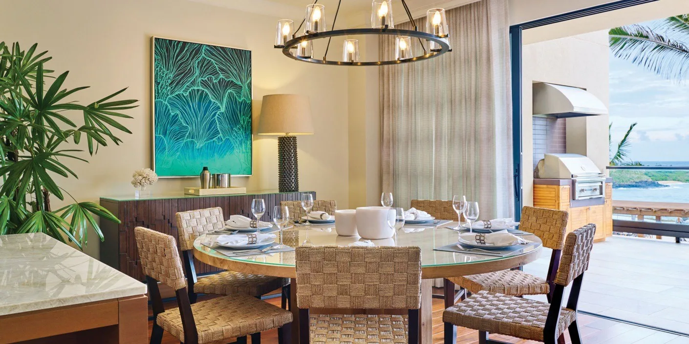 Un comedor con la mesa puesta junto a una vista abierta del agua.