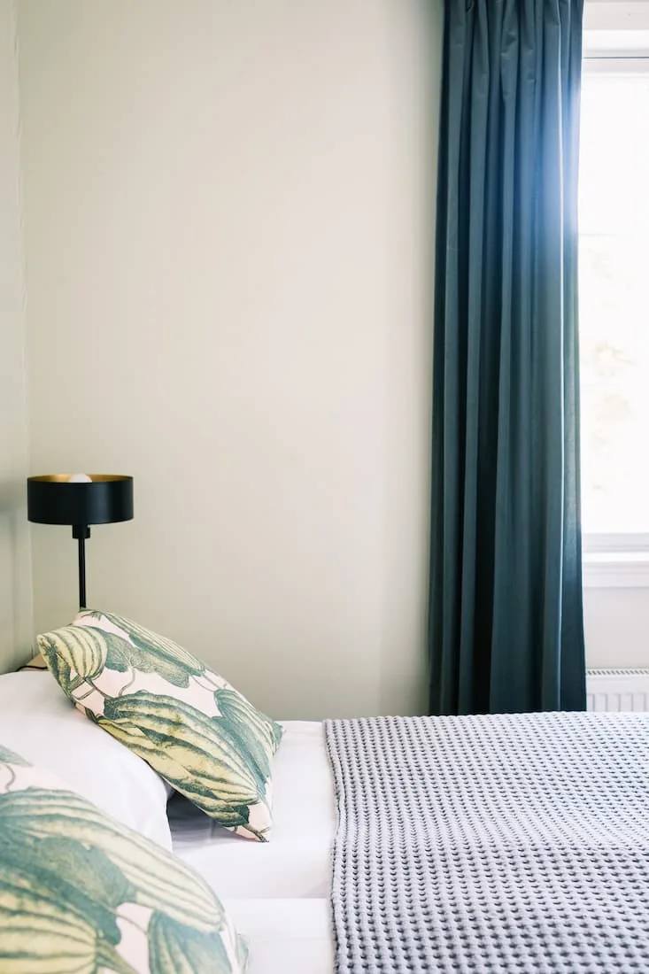 Cama de la habitación Pärlan con detalles verdes.