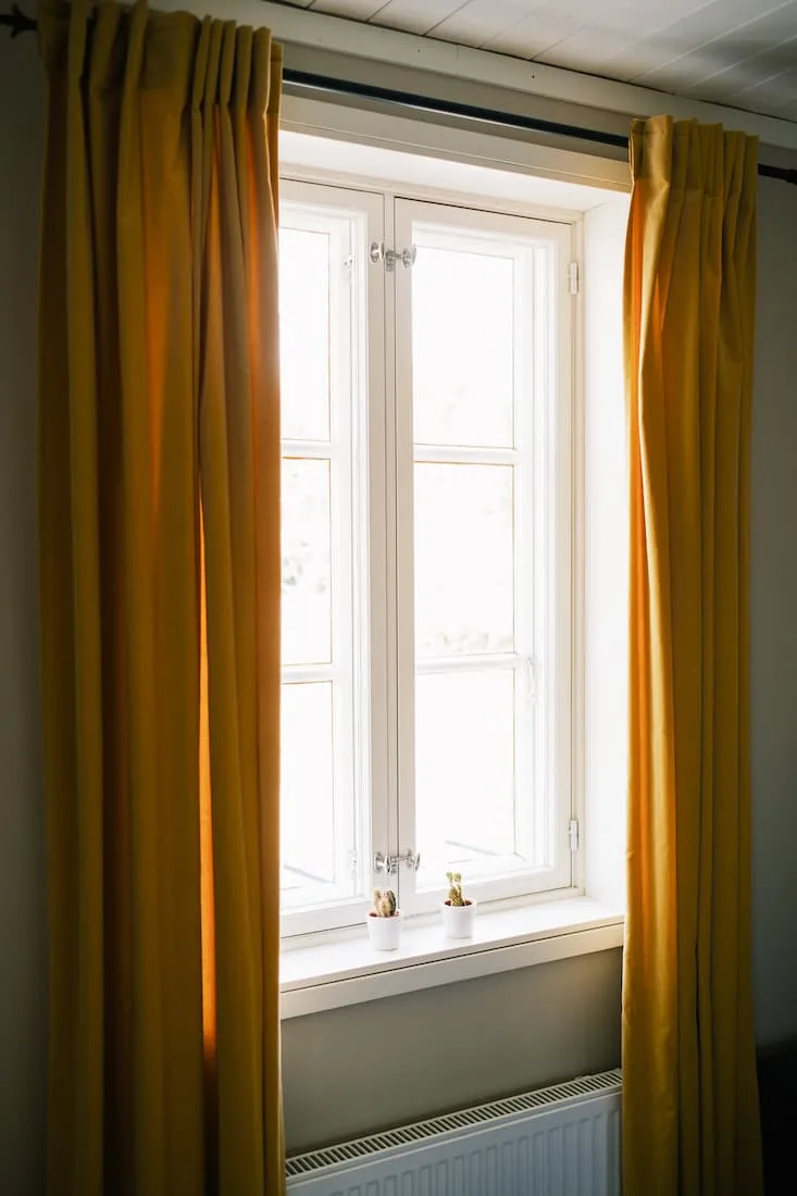 Ventana con cortinas amarillas en Klinga.