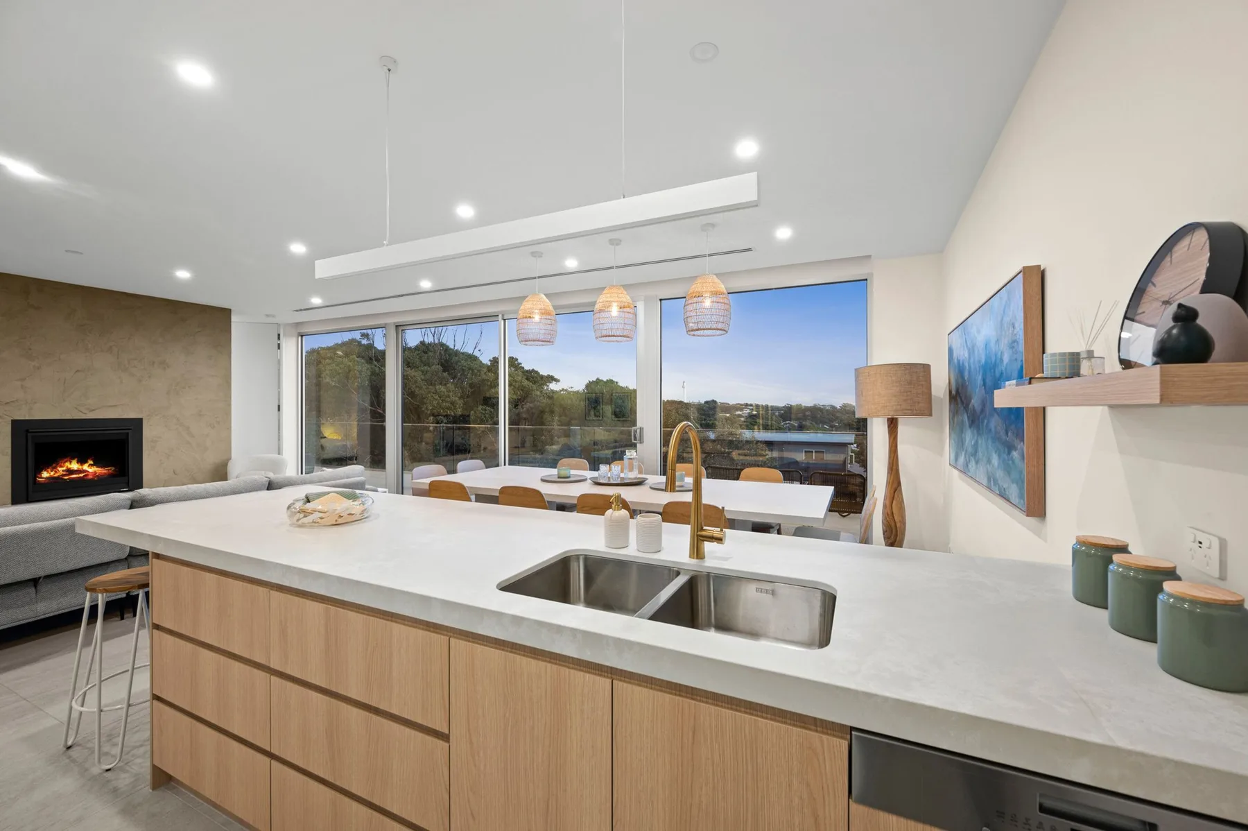 Cocina y comedor de planta abierta con una isla larga y grandes ventanas.