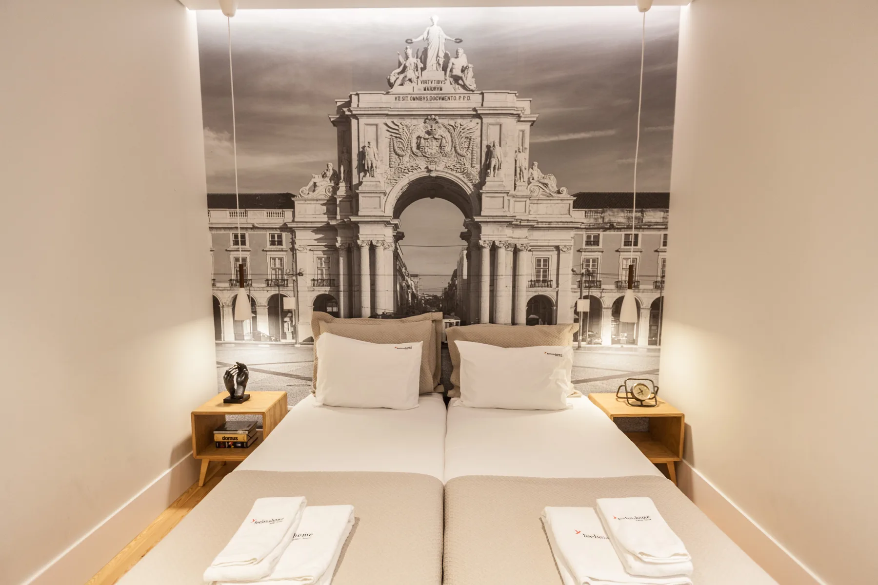 Un dormitorio con una cama doble y un gran mural arquitectónico en blanco y negro.