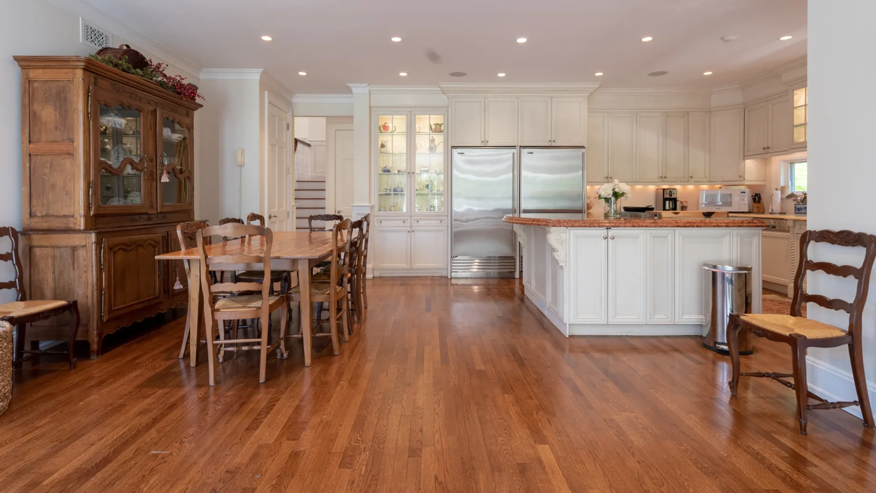 A spacious kitchen and dining area with wooden flooring and a large island.