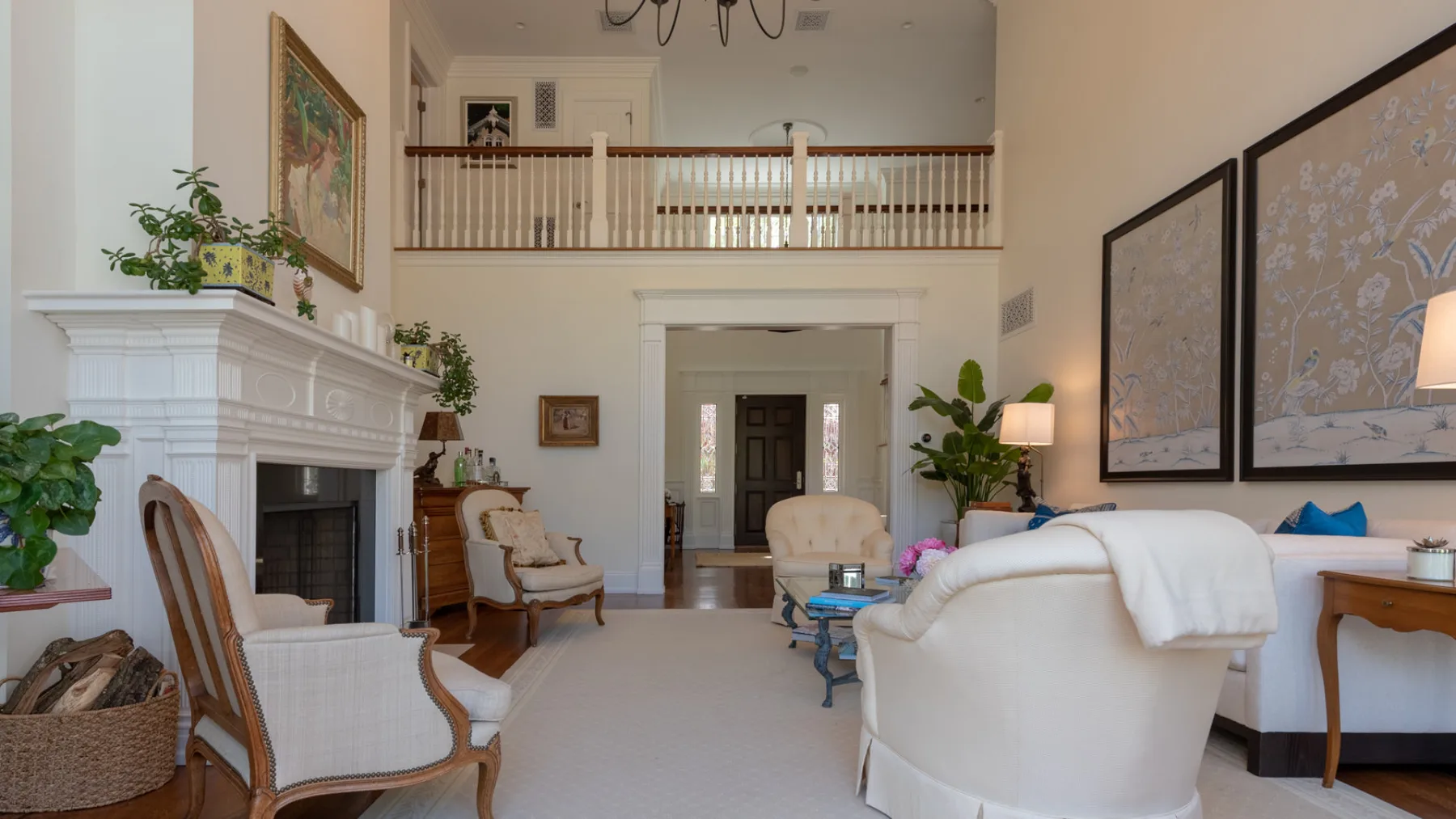 A bright living room with seating arranged around a fireplace.