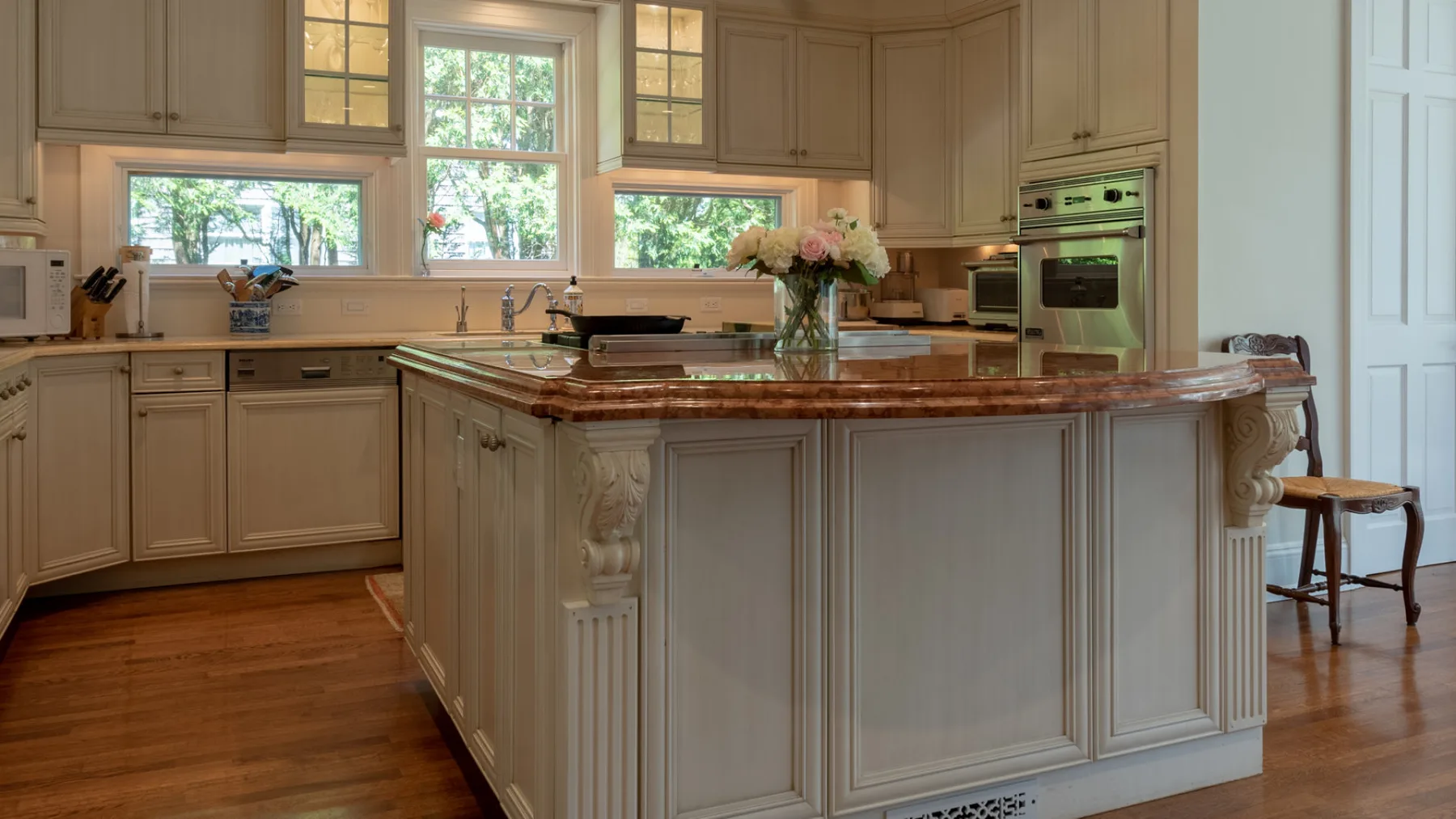 A spacious kitchen with a large central island and windows above the counter.