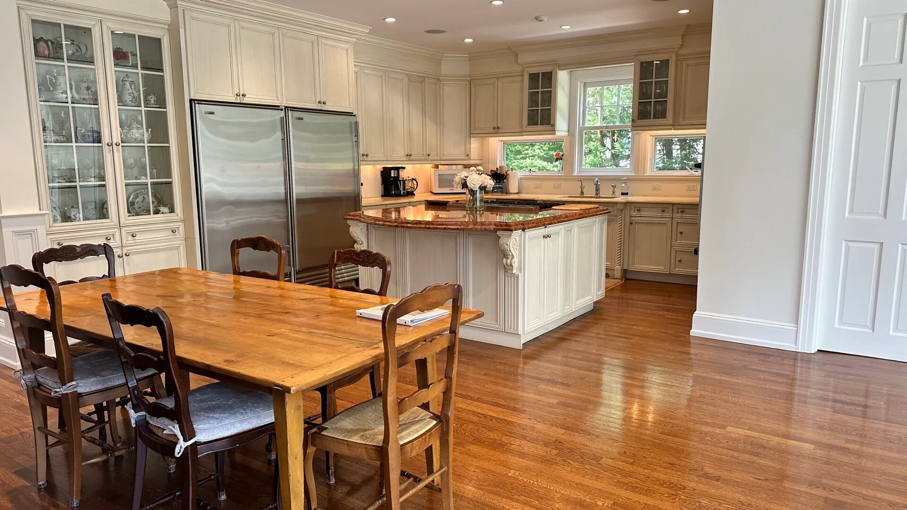 A bright kitchen and dining area with a wooden table and central island.
