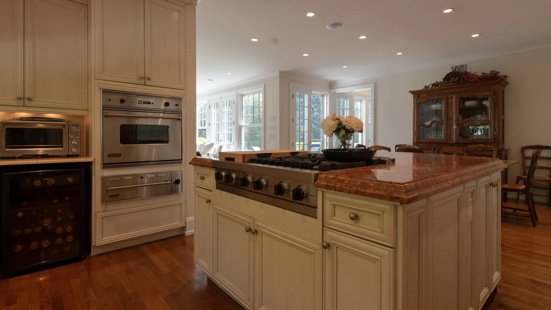 A kitchen with a large island, built-in appliances, and windows in the adjoining dining area.