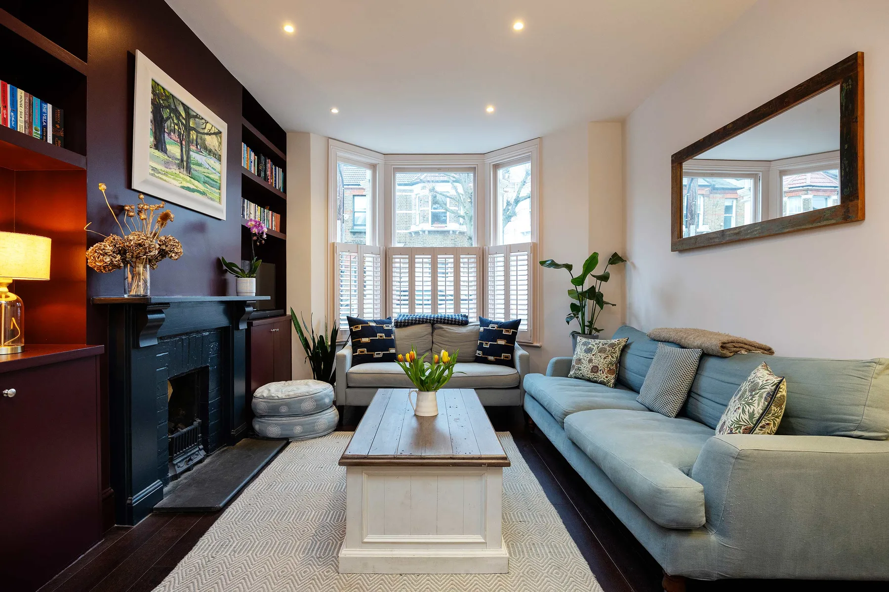 A bright living room with a seating area, coffee table, and large windows.