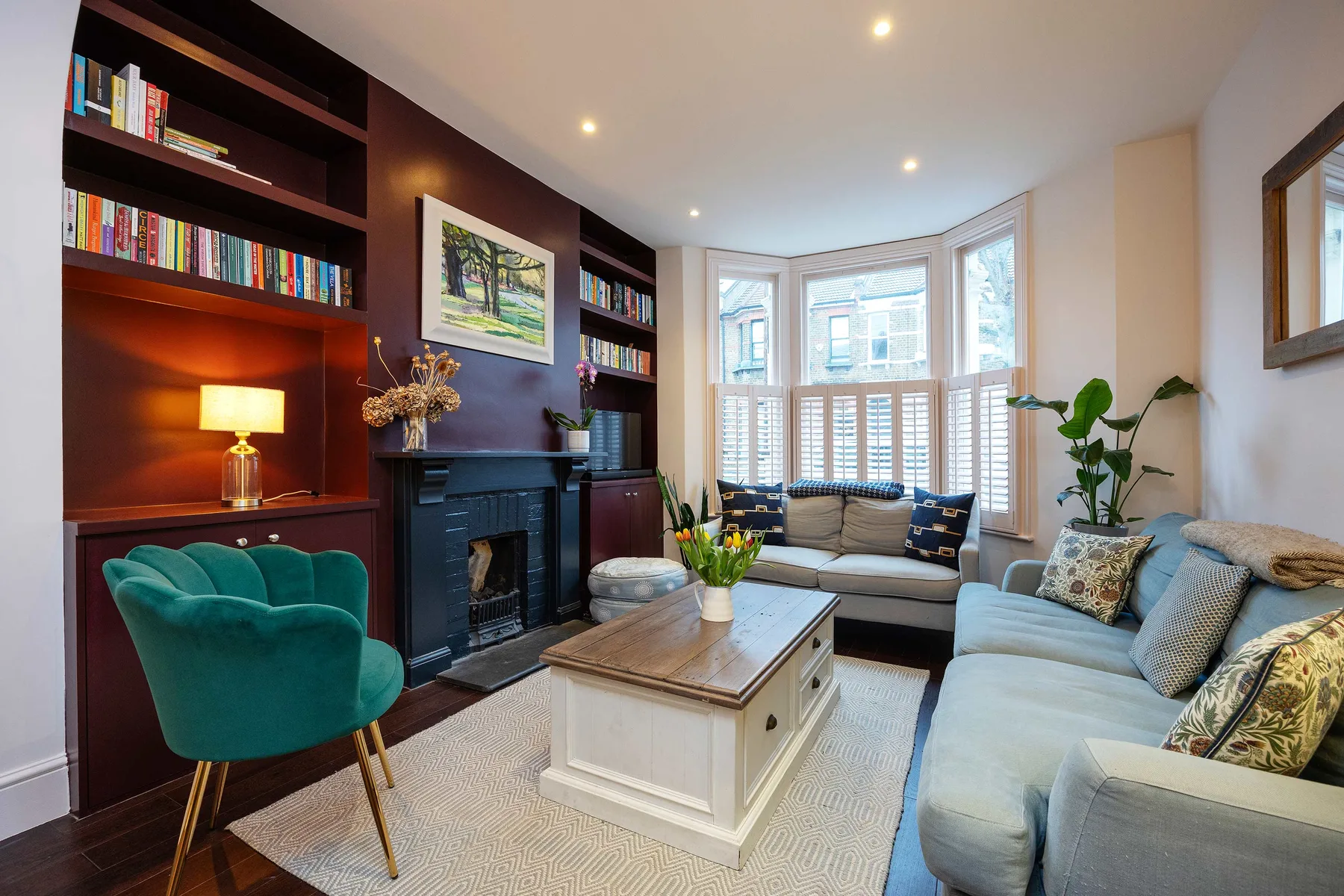 A bright living room with built-in bookshelves, a fireplace, and a seating area.