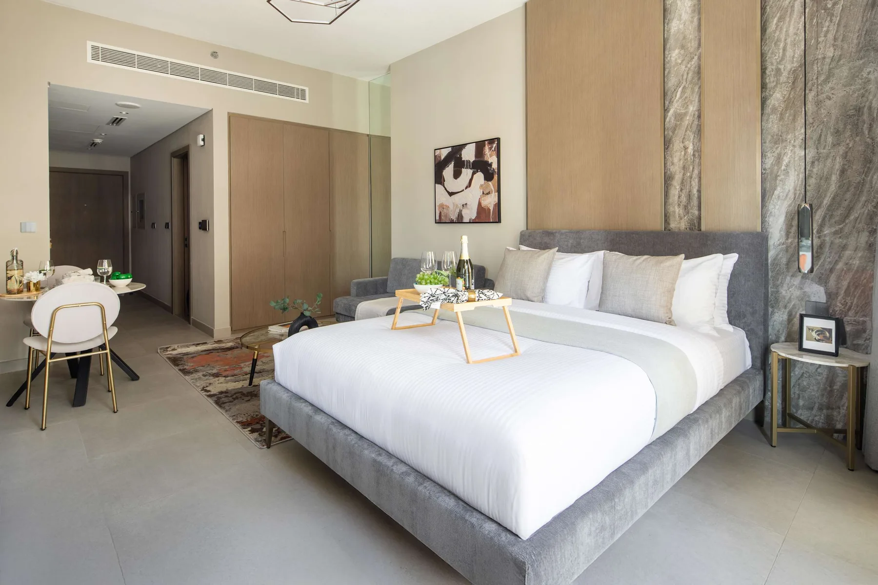 A bedroom with a large bed, bedside tables, and a small dining area.