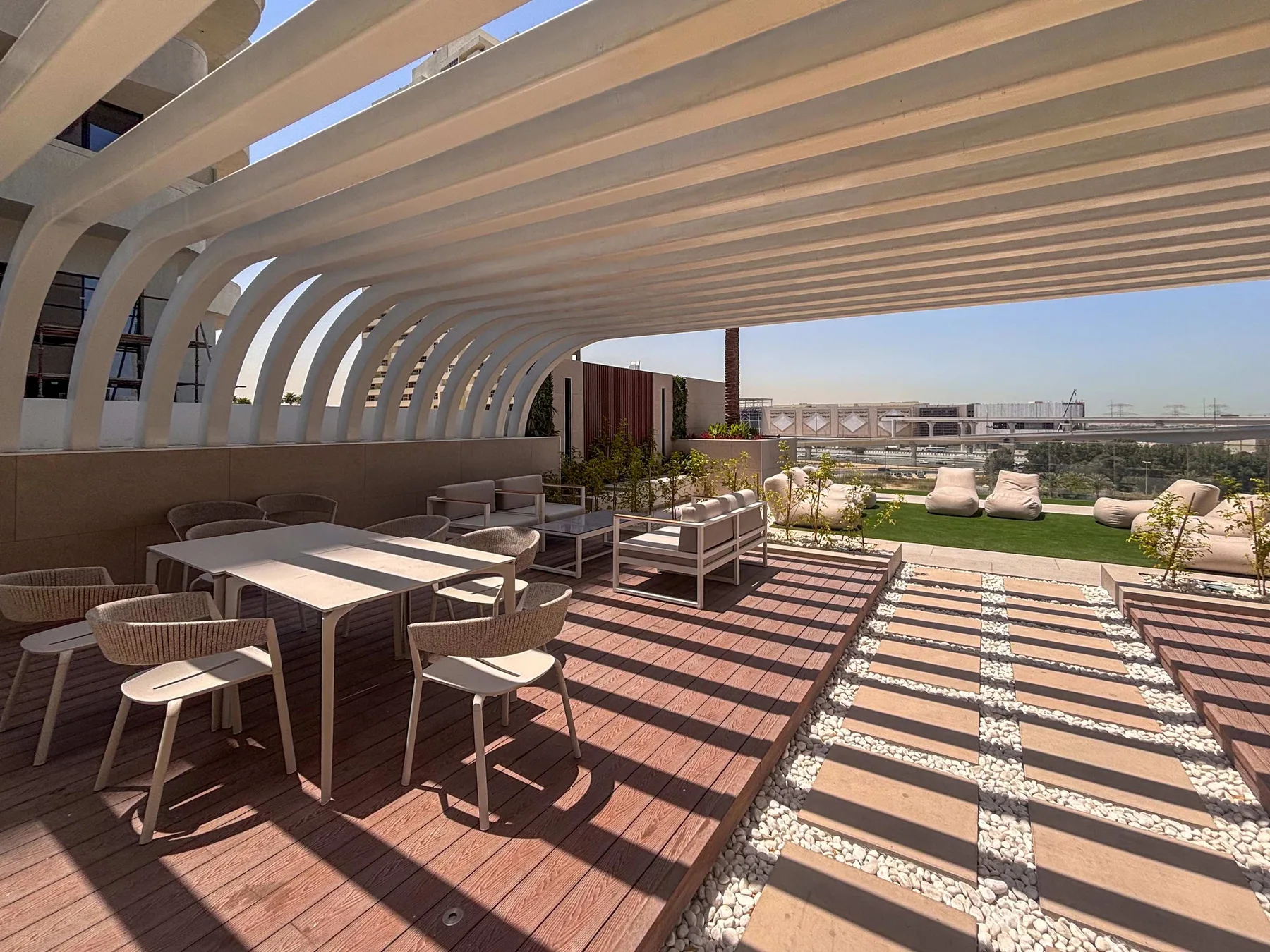 A rooftop terrace with dining seating, a pergola, and an open lounge area.